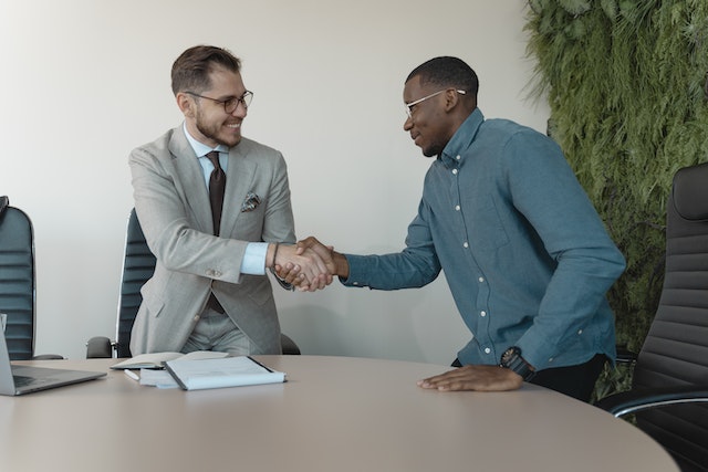 two professionals standing and shaking hands